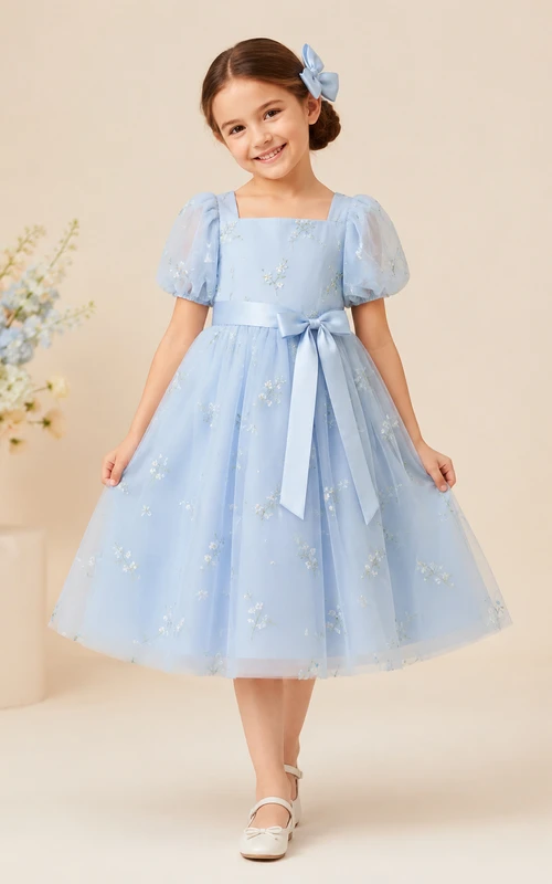 Sencillo vestido de niña de flores de tul con corte en A, cuello joya, falda a media pierna y falda plisada.