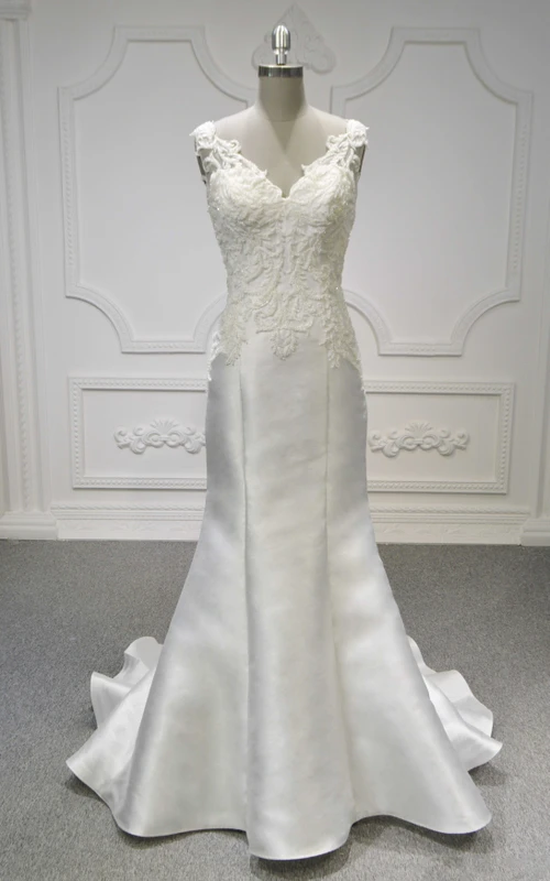 Ärmelloses Brautkleid im Meerjungfrauenstil aus Spitze und Satin mit V-Ausschnitt, Raffungen und transparentem Rückenausschnitt.