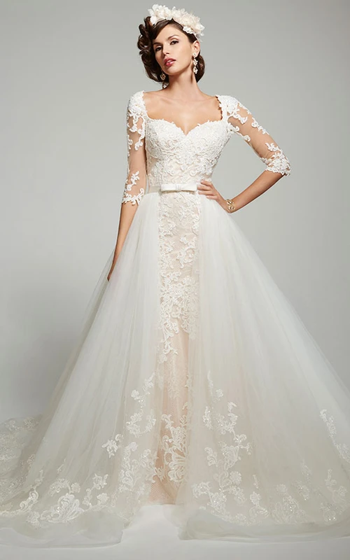 Vestido de gala de tul y encaje con mangas tres o cuatro, escote cuadrado y abertura en forma de ojo de cerradura.