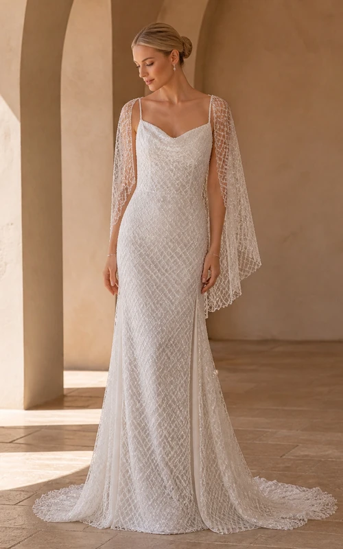 Vestido de novia bohemio de corte recto con mangas murciélago y escote drapeado, encaje geométrico y falda larga.