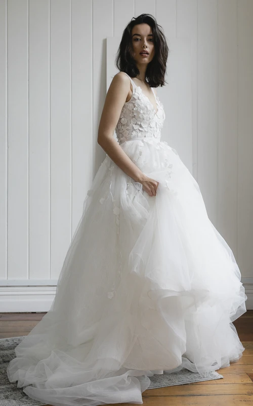 Vestido de novia bohemio sin mangas con escote en V profundo en la espalda y apliques de encaje. Falda de tul.