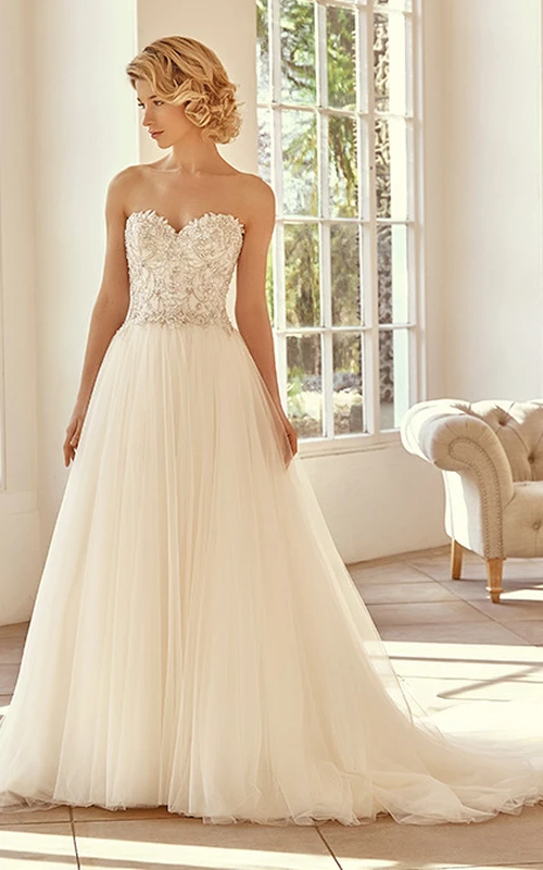Robe de mariée longue en tulle perlé avec décolleté en cœur et traîne courte