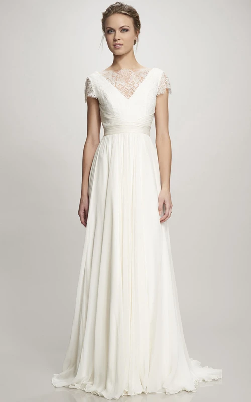 Vestido de novia maxi de gasa con escote barco, mangas cortas fruncidas, cola y espalda en V.