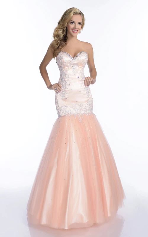 Robe de bal sirène en tulle sans manches, décolleté cœur, ornée d'appliques et de finitions en strass.