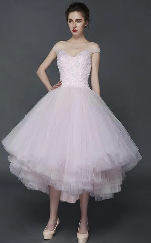 Vestido de fiesta asimétrico con corte en A, hombros descubiertos, detalles de pedrería y pliegues.