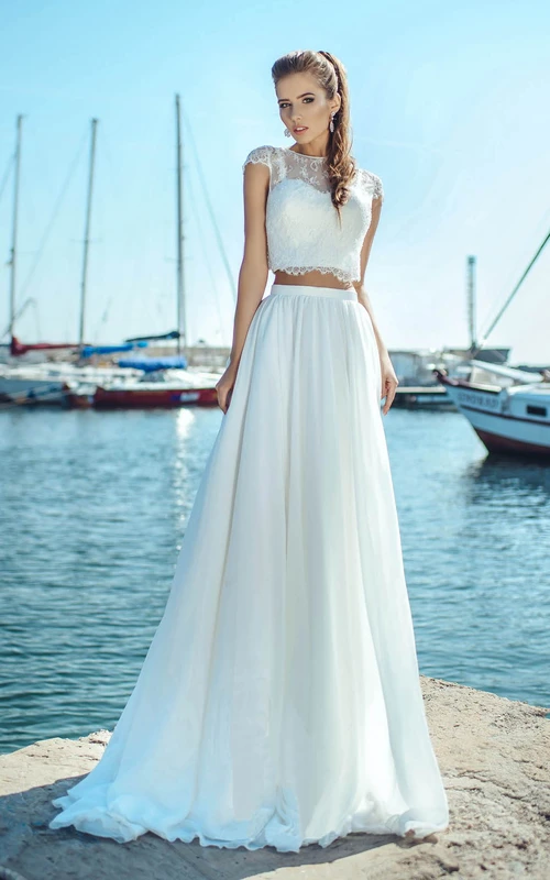 Robe de mariée vaporeuse deux pièces à col rond et manches courtes, ornée d'appliqués. Style simple et vaporeux.