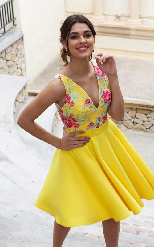 Vestido corto de fiesta amarillo con escote en V pronunciado, corte imperio y bordados.