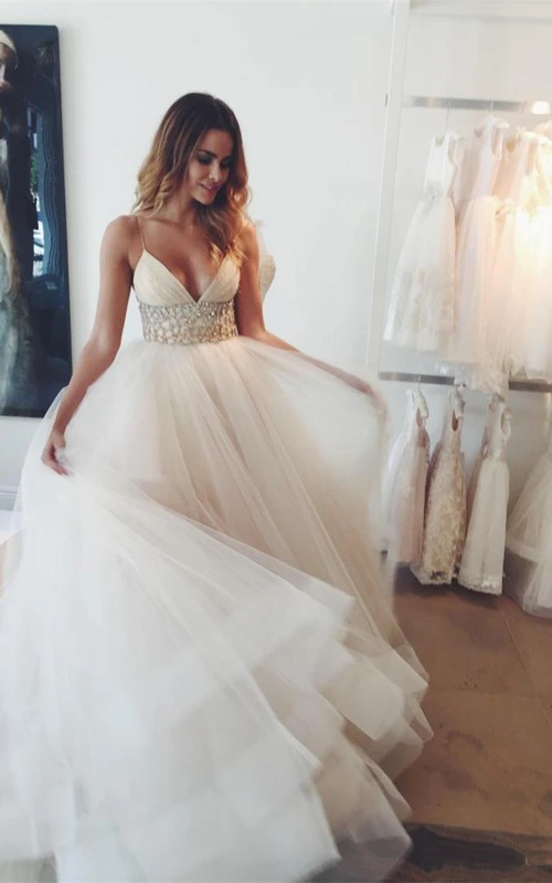 Vestido de novia bohemio con tirantes finos, fajín, cuentas, lentejuelas, capas de tul y cremallera en la espalda.