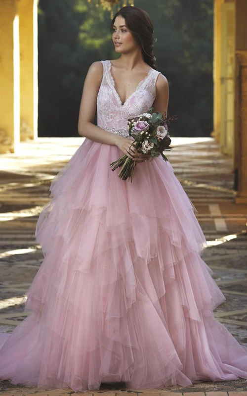 Robe de mariée longue en tulle, coupe trapèze, à volants cascade, sans manches, col en V, ornée de dentelle et de bijoux de taille.