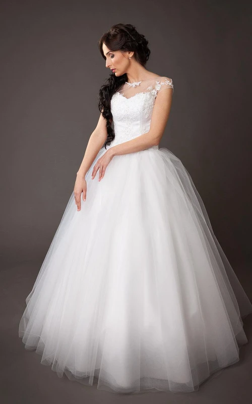 Vestido de gala de tul con mangas cortas, corte en A, corpiño de encaje y escote barco.