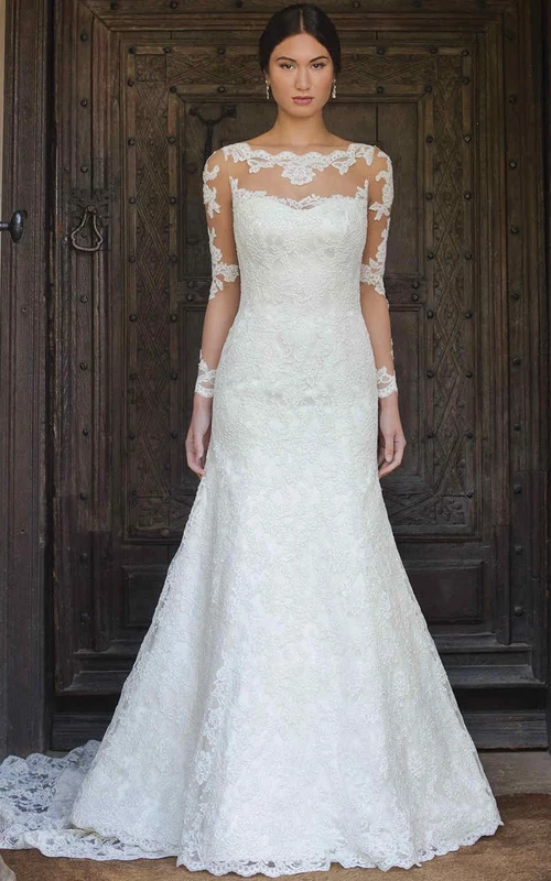 Vestido de novia largo de encaje con escote barco, corte en A, manga larga, apliques y efecto ilusión.