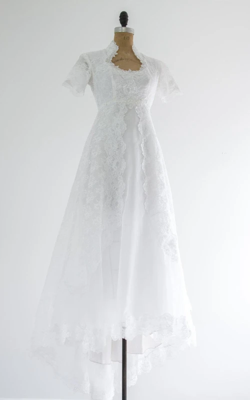 Robe en dentelle à manches courtes et décolleté Reine Anne, coupe trapèze, ornée de perles