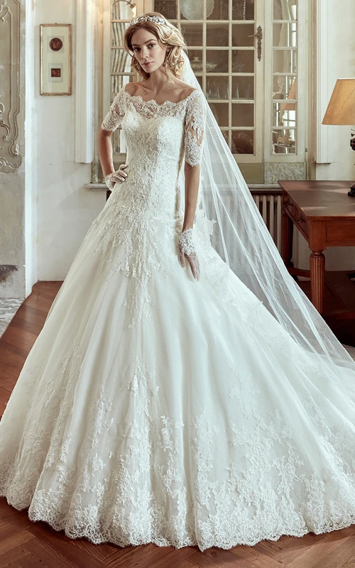 Vestido de novia de corte A con hombros descubiertos, mangas cortas y cola de corte princesa.