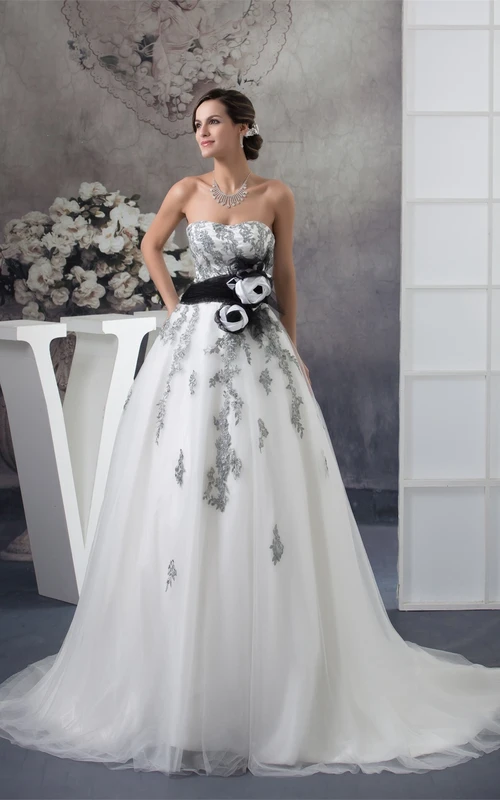 Vestido de gala sin mangas con superposición de tul y apliques florales.