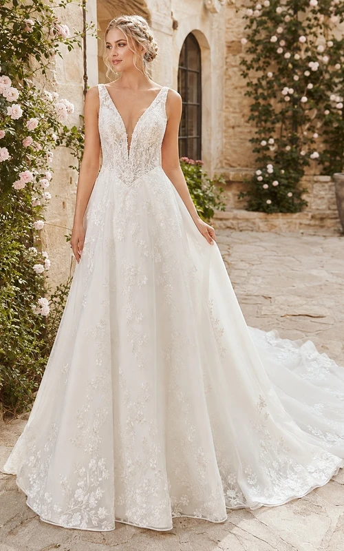 Vestido de novia de corte A con encaje y cintura estilo vasco, tirantes finos y punta puntiaguda, ideal para bodas al aire libre.