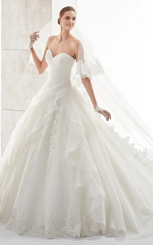 Vestido de novia de corte A con escote corazón, volantes laterales y corpiño plisado.