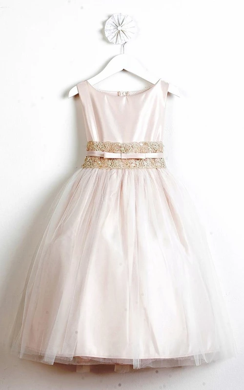 Robe de demoiselle d'honneur mi-longue en tulle et dentelle à volants, ornée d'un nœud et d'une ceinture.
