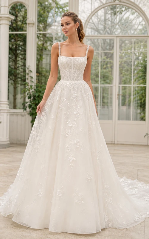 Robe de mariée traditionnelle en dentelle et tulle, col carré, sans manches, coupe trapèze, traîne chapelle, applications florales, idéale pour un mariage à destination.
