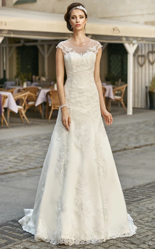 Robe de mariée en dentelle et satin, coupe trapèze, manches courtes appliquées, décolleté rond, longueur au sol.