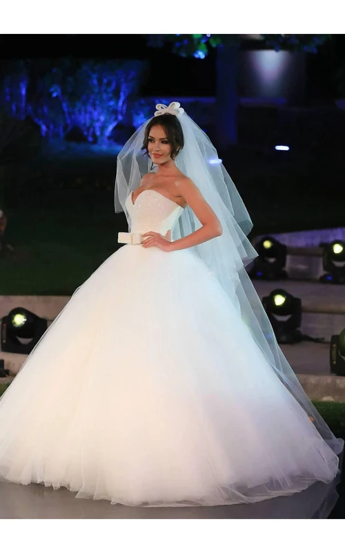 Vestido de novia de gala con escote en V, tul, lentejuelas y lazo.