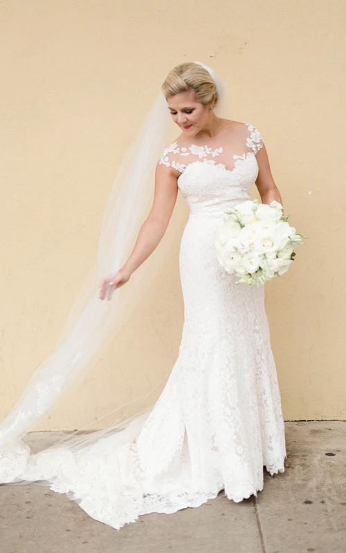 Vestido de sirena con cintura imperio, mangas cortas de encaje y apliques florales.