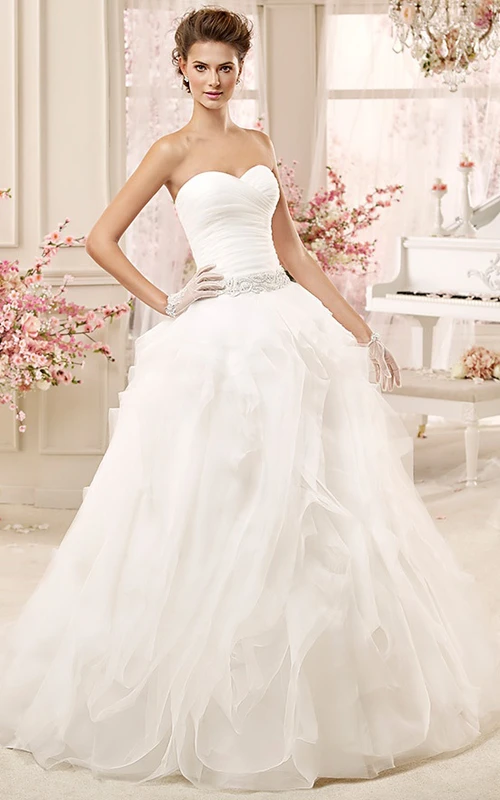 Vestido de novia con escote corazón, fruncido, cinturón de cuentas y corpiño plisado.