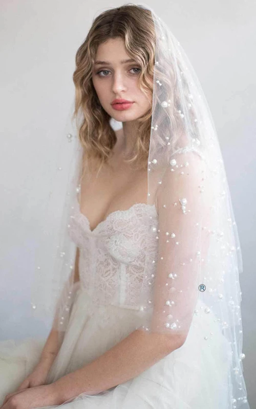 Voile de mariée romantique en tulle orné de perles, arrivant au bout des doigts