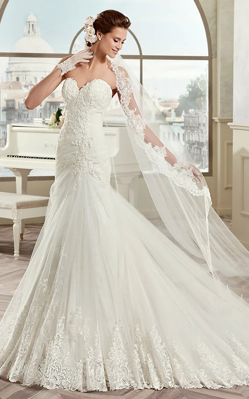 Vestido de novia de corte recto con encaje y escote corazón, con apliques y espalda ladeada.