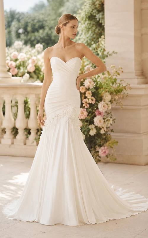 Vestido de novia estilo sirena sin tirantes con corpiño fruncido y bajo acampanado.