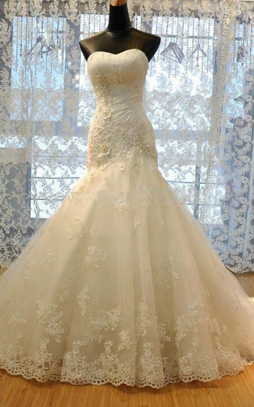 Robe sirène sans manches à bretelles longues et volants cloche, laçage au dos, en dentelle, organza et satin.