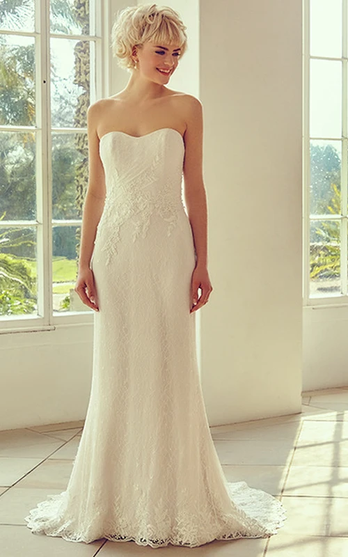 Robe de mariée bustier longue en dentelle appliquée avec traîne.