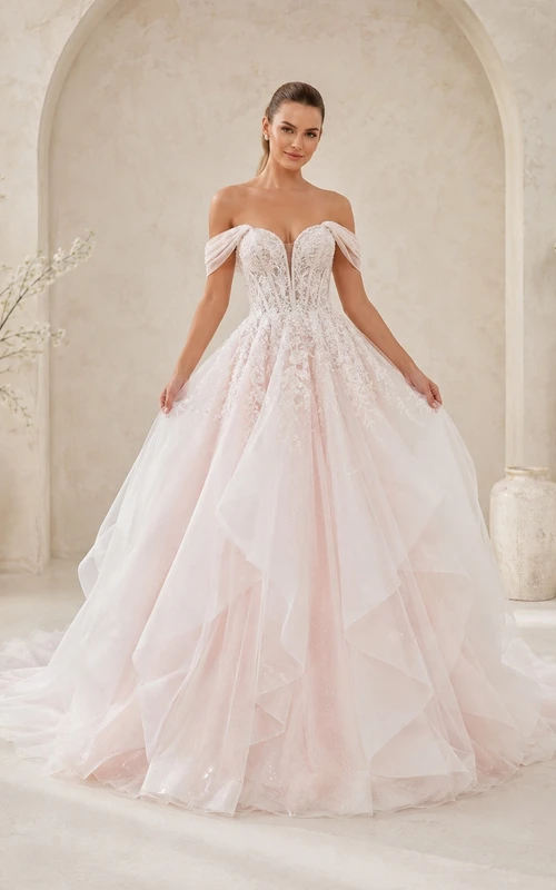 Romantisches Brautkleid aus Tüll in zartem Rosa mit schulterfreiem Ausschnitt und Rüschenschleppe