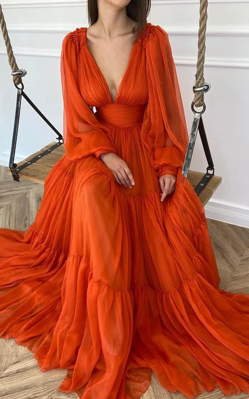 Vestido de gasa con escote en V, mangas largas abullonadas y corte imperio.