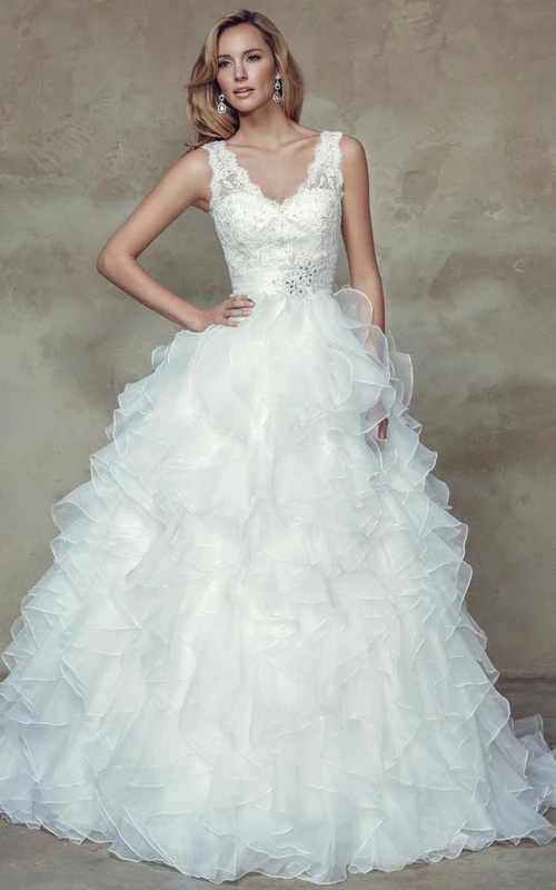 Vestido de novia de organza largo hasta el suelo con escote en V, apliques, sin mangas, volantes en cascada y espalda baja en V.