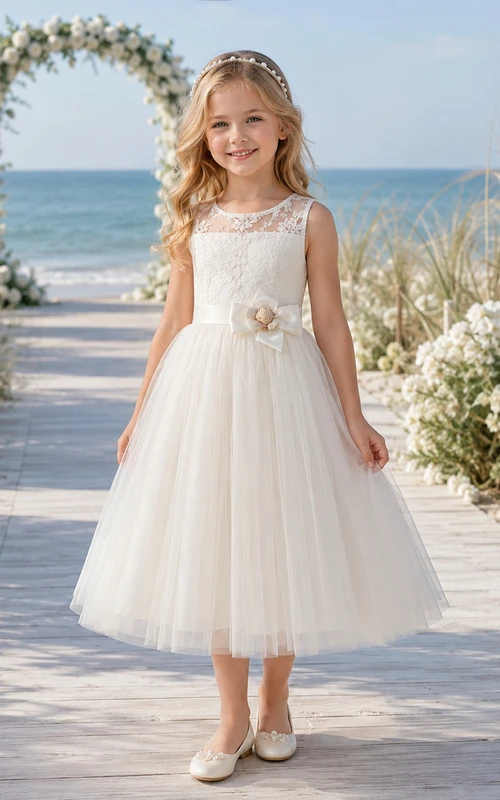Elegante vestido de niña de las flores con corte en A, corpiño de encaje, falda de tul y lazo en la cintura para ceremonia en la playa.