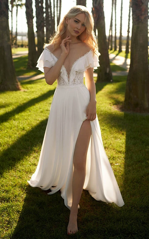 Vestido de novia de gasa con escote pronunciado, hombros descubiertos y abertura frontal, con espalda ilusión.