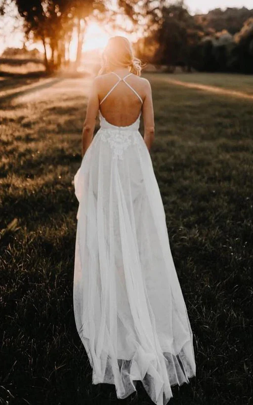 Vestido de novia bohemio de corte imperio, sin espalda y con tirantes finos y encaje.