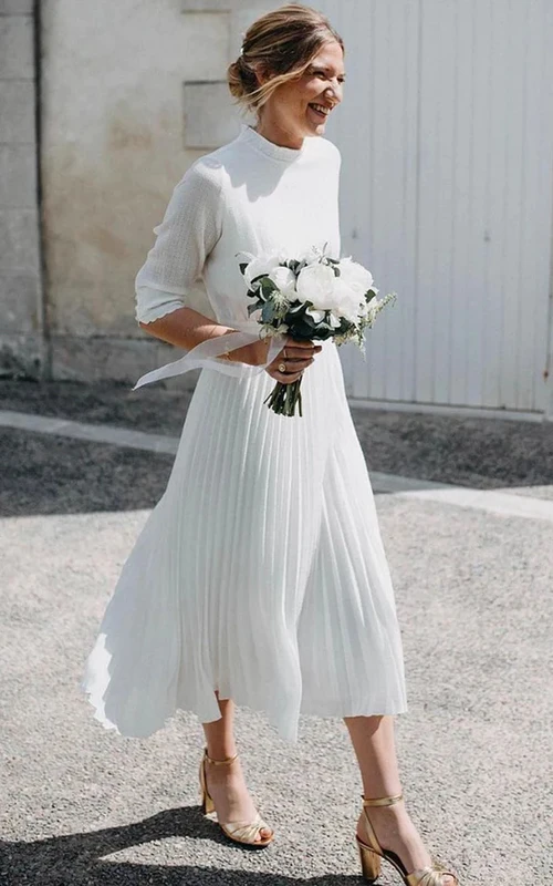 Robe de mariée mi-longue en mousseline plissée, simple, à col rond et manches mi-longues, avec dos nu en forme de goutte.
