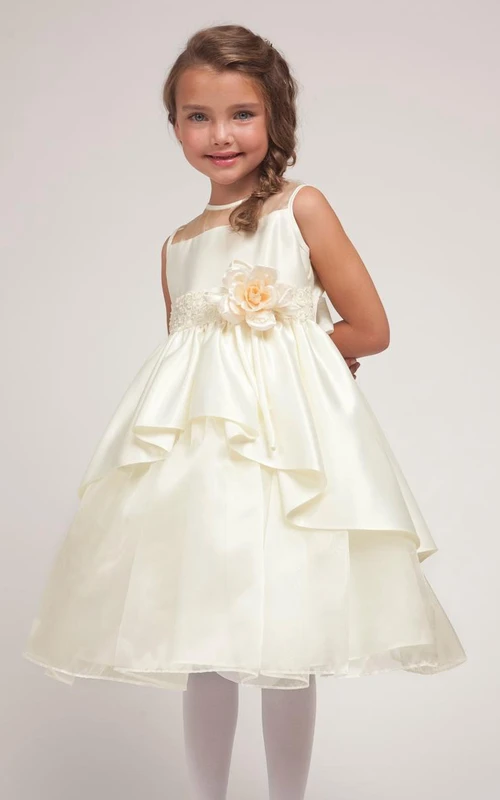 Robe de demoiselle d'honneur mi-longue à volants en dentelle et organza à motifs floraux, avec ceinture.