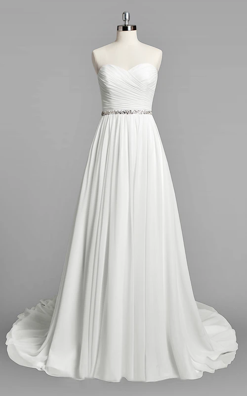Robe de mariée simple en mousseline de soie, coupe trapèze, ornée de fronces et de perles