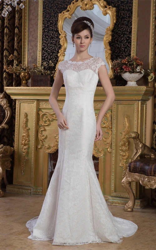 Vestido de encaje estilo sirena con escote barco, mangas con capa y cola larga.