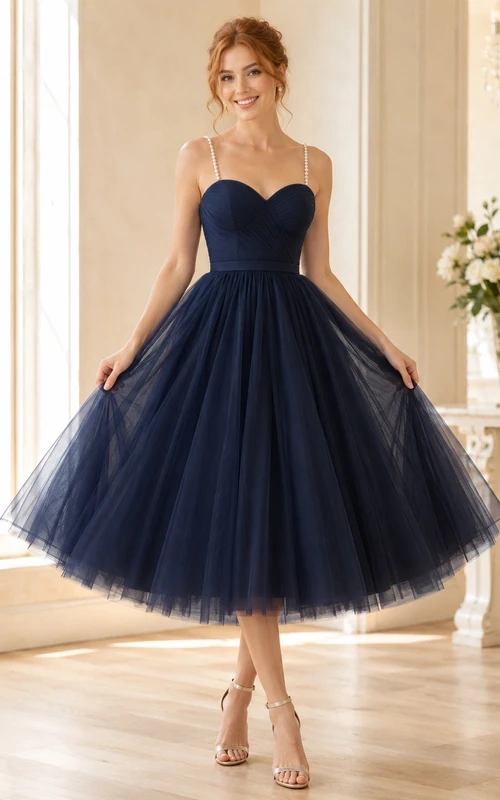 Robe de bal bleu marine en tulle longueur thé, décolleté en cœur, taille structurée, jupe ample et volants.