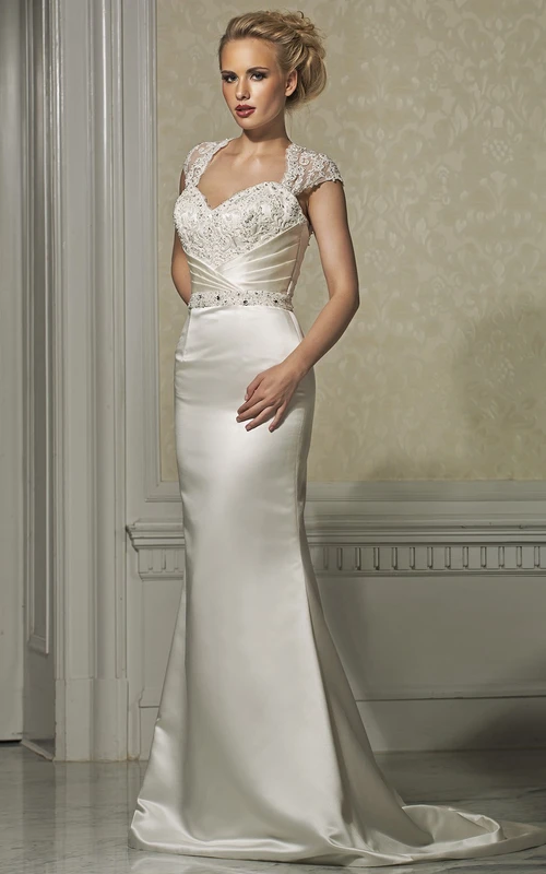 Robe de mariée fourreau en satin ornée de bijoux et de dentelle, manches courtes et longueur au sol.