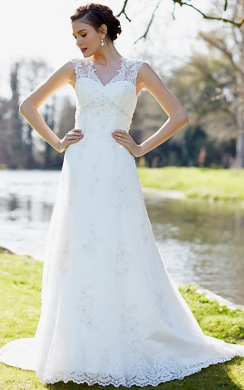 Vestido de novia largo hasta el suelo, con escote en V, sin mangas, de encaje y con apliques y pedrería.