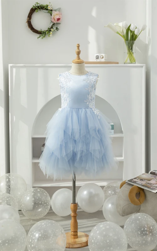 Hellblaues, kurzes Blumenmädchenkleid aus Tüll mit Rundhalsausschnitt, Applikationen und Rüschen.