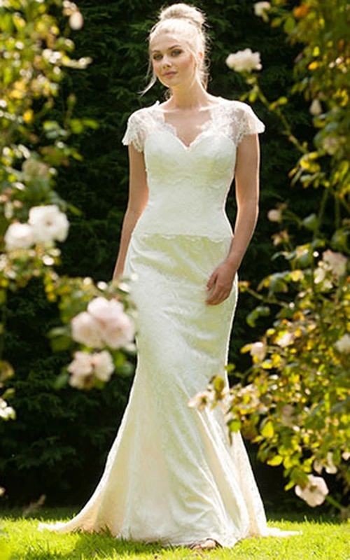 Vestido de novia largo con escote en V, mangas cortas, apliques de encaje, cola y espalda en V.