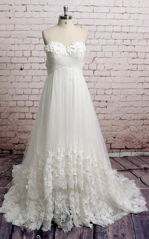 Robe de mariée empire en dentelle et tulle, bustier cœur, ornée de pétales et de fronces croisées
