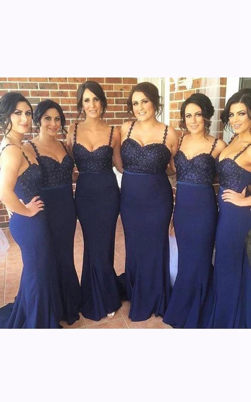 Vestido sin mangas con tirantes finos, cola larga y detalles de pedrería.