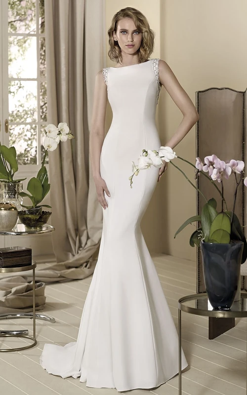 Vestido de novia sin mangas, largo hasta el suelo, con escote barco y detalles de cuentas.