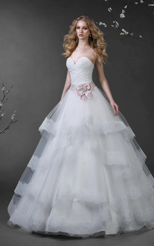 Vestido largo de gala con escote corazón, sin mangas, de tul, con cordones, volantes y pedrería.